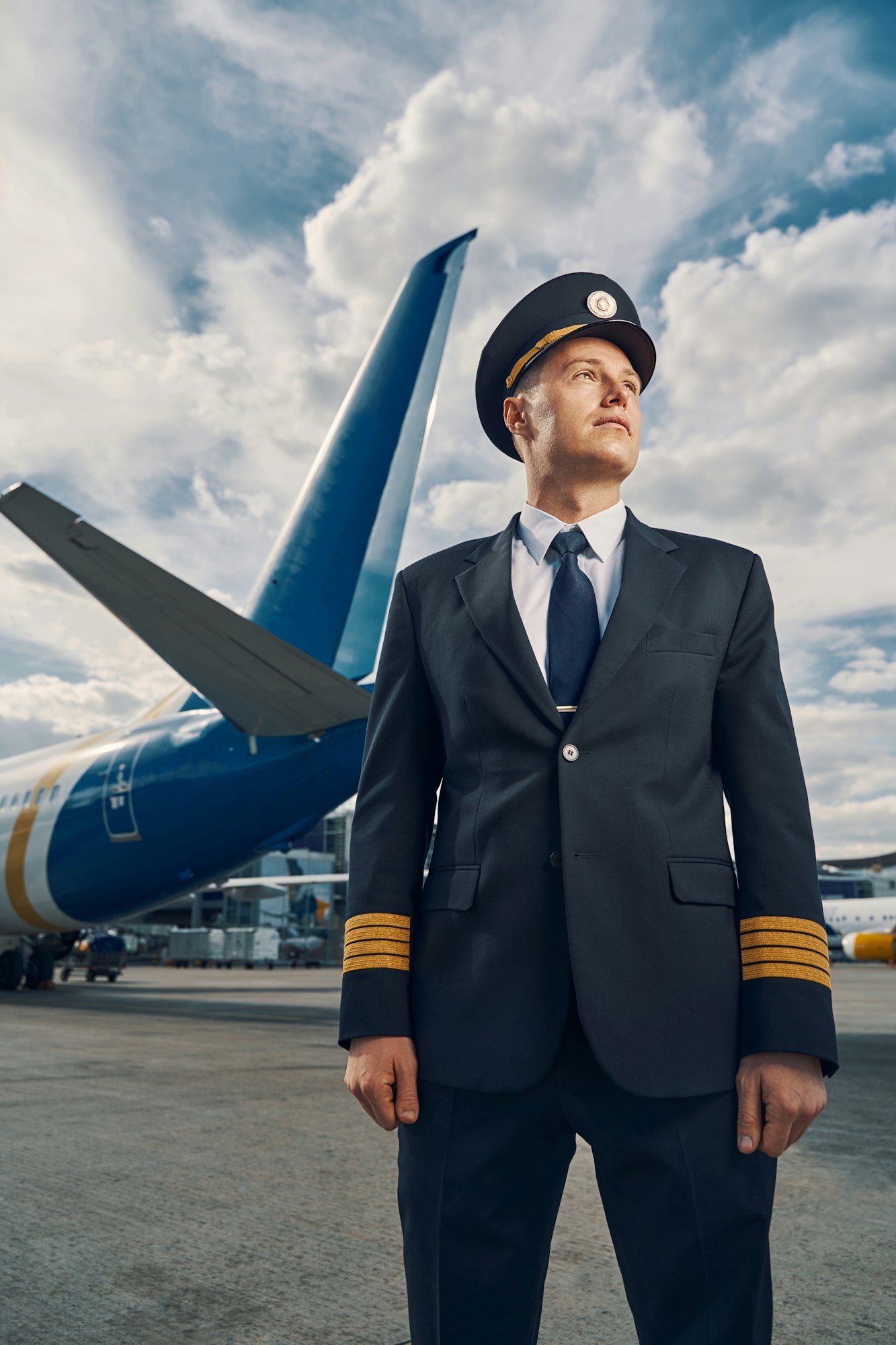 Attractive professional aviator dressed in uniform looking away